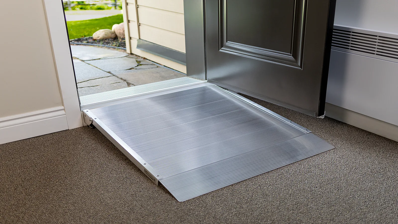 Passe-seuil en aluminium installé au seuil d’une porte battante